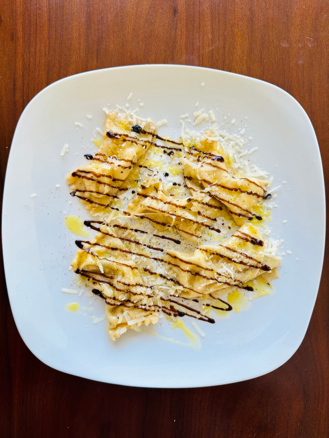 Handmade ravioli on a white plate, photographed by Pasta Mark